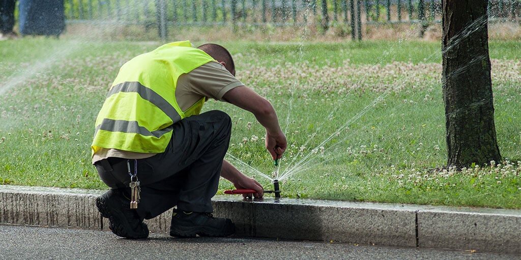 Worker repairing sprinkler system